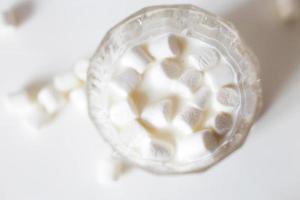 marshmallow i en glas av mjölk. marshmallows på en vit bakgrund foto