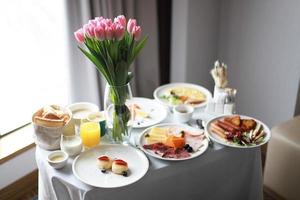 tabell med frukost och blommor foto