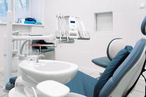 närbild av dental Utrustning i tandvård klinik. arbetsplats och verktyg av tandläkare. dental stol och kirurgisk instrument foto