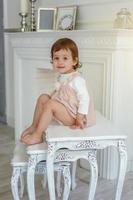 liten flicka Sammanträde på modern stol foto