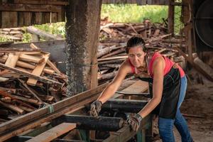 porträtt av en kvinna ser till de sida med orolig ansikte, arbetssätt i en sågverk. foto
