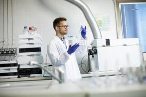 ung forskare som arbetar med kemiska prover i laboratorium med hplc-system och kromatografiutrustning