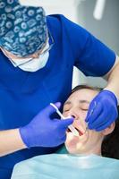 dental behandling. dental kontor. läkare behandlar tänder. kvinna i tandvård.dental behandling. dental kontor. läkare behandlar tänder. foto
