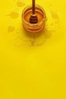 burk med honung på gult bord med kopieringsutrymme