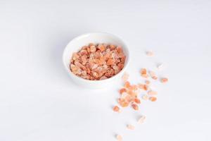 himalayan rosa sten salt. mineralrik salt från de himalayan område. i keramisk burk på vitt bakgrund. foto