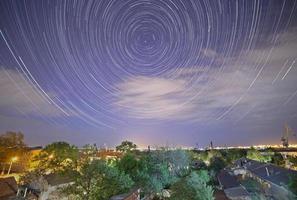 spår av stjärnor i natt himmel ovan stad foto