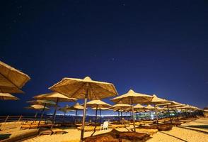 parasoll strand paraplyer mot natt himmel i egypten foto