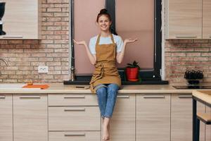 ung brunett kvinna på kök disken foto