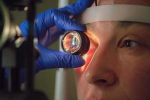 ett ögonläkare checkar de fundus av de patient. foto