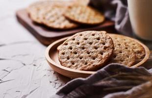 hela spannmål vete runda crackers och mjölk på vit tabell bakgrund foto