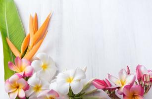 vit trä textur med heliconia och plumeria blomma foto