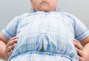 fet fett pojke övervikt. tajt skjorta av pyjamas foto
