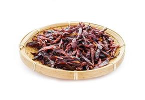 lugg av torr röd chili chili peppar i trä bambu tallrik isolerat på vit mat kryddor bakgrund. chili, chili, peppar foto