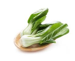 lugg av bebis bok choy eller pak choy i trä tallrik isolerat på vit bakgrund. högen av bok choy isolerat. grön bok choy isolerat foto