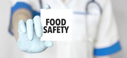 läkare innehav en kort med text mat säkerhet, medicinsk begrepp foto