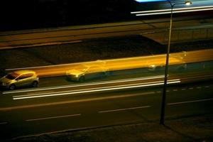 nattväg med suddiga trafikljusspår, lång exponering foto
