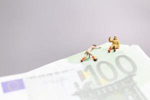 miniatyrfolk, klättrare klättrar på en eurosedel, affärsidé. foto