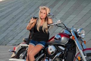 sexig blondin sitter på sin motorcykel foto