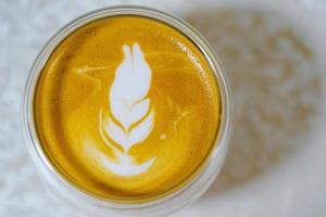 hemlagad varm kaffe lattekonst och mjölkskum, perfekt cappuccino i en vit kopp på vit bakgrund. närbild och makrofotografering.