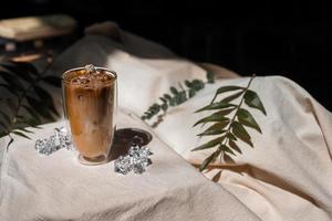 närbild glas iskaffe med mjölk på bordet foto