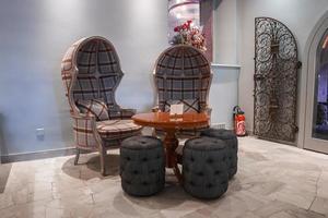 tömma stolar med ottomaner runt om tabell i rum på lyx tillflykt foto