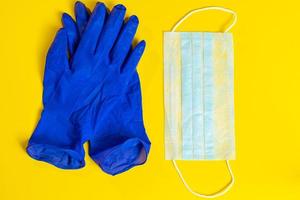 latexhandskar och medicinsk ansiktsmask på en gul bakgrund. förebyggande skydd mot koronavirus.