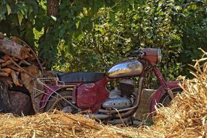 gammal antik motorcykel i främre av en turkiska hus hänger på en sommar dag foto