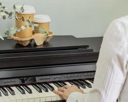 kvinna spelar på piano med ro och två koppar av kaffe foto