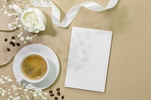 kopp av kaffe, mjölk och kaffe bönor på beige bakgrund med posta kort foto