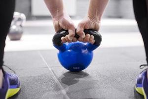 ung flicka innehav en kettlebell. sneakers. sport. crossfit foto