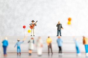 miniatyr- sångare och musiker spelar en gitarr på skede, värld musik dag begrepp foto