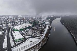 vinter- panorama- antenn se av de rök av rör av en kemisk växt eller träbearbetning företag. luft och vatten förorening begrepp. foto