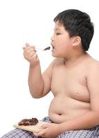 fet pojke äta choklad isolerat på vit foto