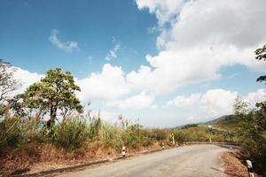 gul tecken märka varning av kurva väg på de berg i thailand foto