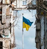 flagga av ukraina mot de bakgrund av en förstörd byggnad i ukraina foto