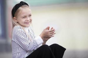 porträtt av en Lycklig liten flicka med blond hår. foto