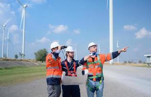 besiktningsman och ingenjör undersöka de effektivitet av gigantisk vind turbiner den där omvandla vind energi in i elektrisk energi den där är sedan Begagnade i dagligen liv. foto