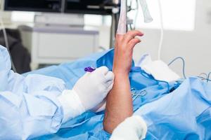 ortopedisk kirurg märkning de kirurgisk webbplats bara innan utför en handled artroskopi på en manlig patient foto