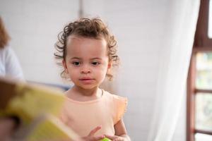 liten flickans far läsa berättelser till barn innan gående till säng till koppla av och sömn lugnt fram tills de morgon. foto