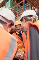 de chef uppmuntrad de lager arbetare till arbete hård till skaffa sig de varor ut av de lager till Avsluta de små köpmän i kväll. förbi sammanfogning händer och skapande en bom foto