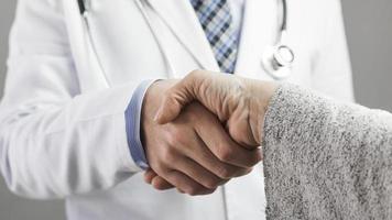 närbild av manlig läkare och patient som skakar hand