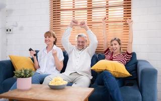 på de familj levande rum soffa, far, mor och dotter lyckligt betraktade de familjens favorit tv show. foto