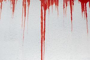 röd måla flöden tvärs över vit vägg. blod kör ner yta. graffiti textur. foto