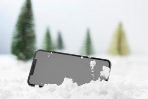 närbild av smartphone i snö foto