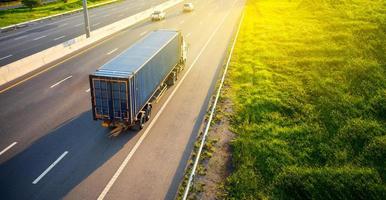 topp se av vit lastbil rörelse fläck på motorväg väg med behållare, transport koncept., import, export logistisk industriell transport landa transport på de motorväg.mjuk fokus foto