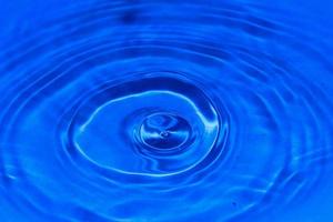 vatten droppar falla på de blå vatten yta foto