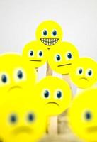 närbild skott av gul smiley ansikte emoji mellan ledsen emojis foto