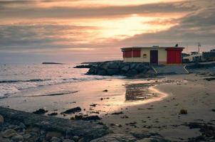skön solnedgång kust landskap med strand hus på sandig salthill strand i galway, irland foto