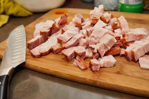 kock nedskärningar bacon i de kök för recept foto