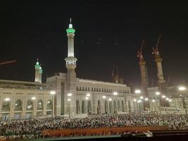 mecka, saudi Arabien, april 2023 - en skön se av pilgrimer, lång byggnader och lampor på natt på de yttre väg i masjid al-haram, mecka. foto